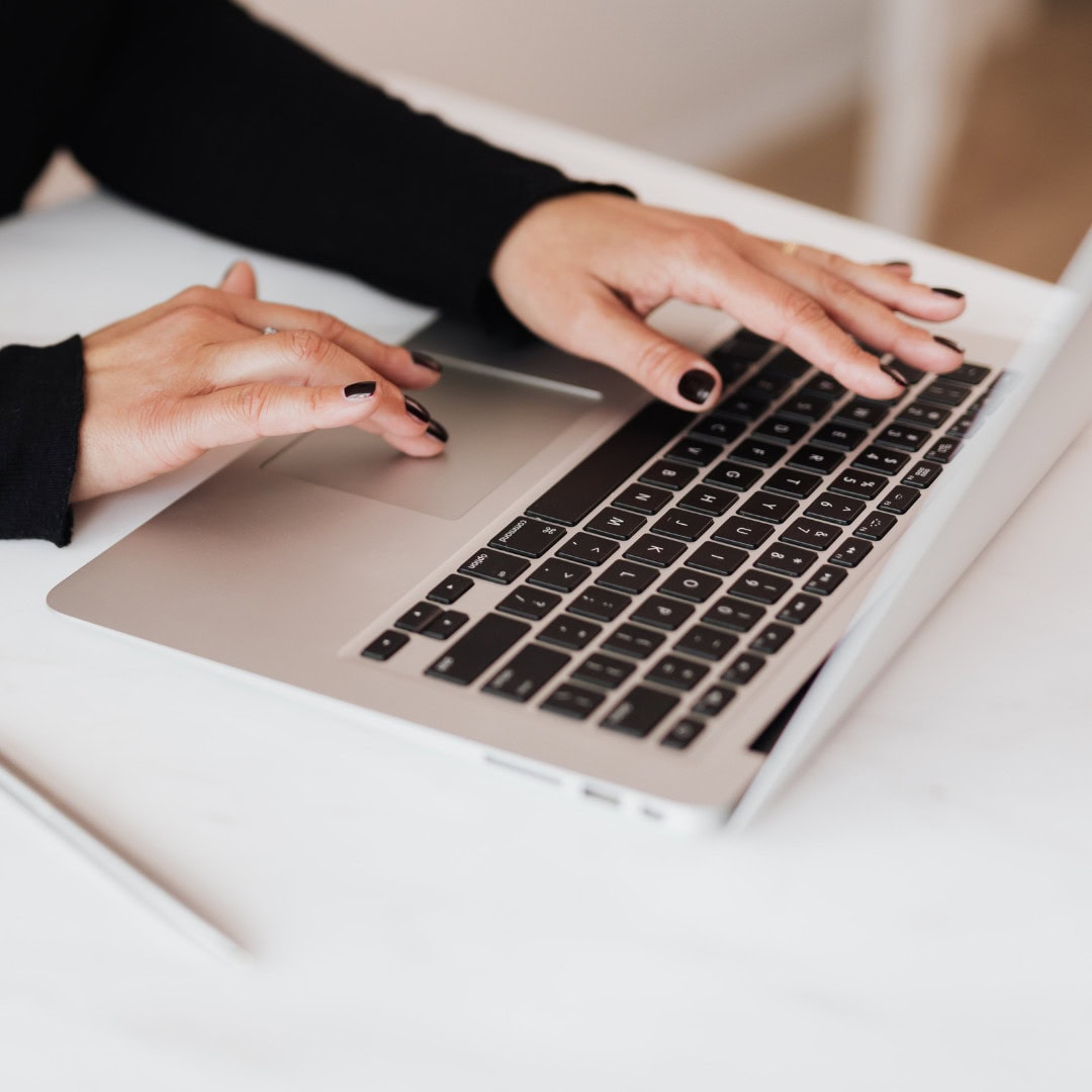Browsing Products on a Laptop Close-up of hands using a laptop, browsing or typing.